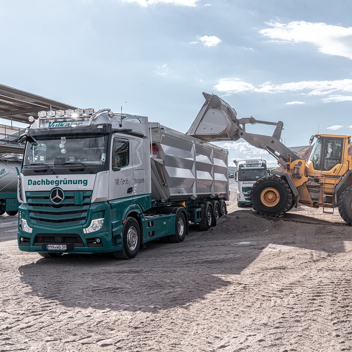 Bagger kippt Material in LKW